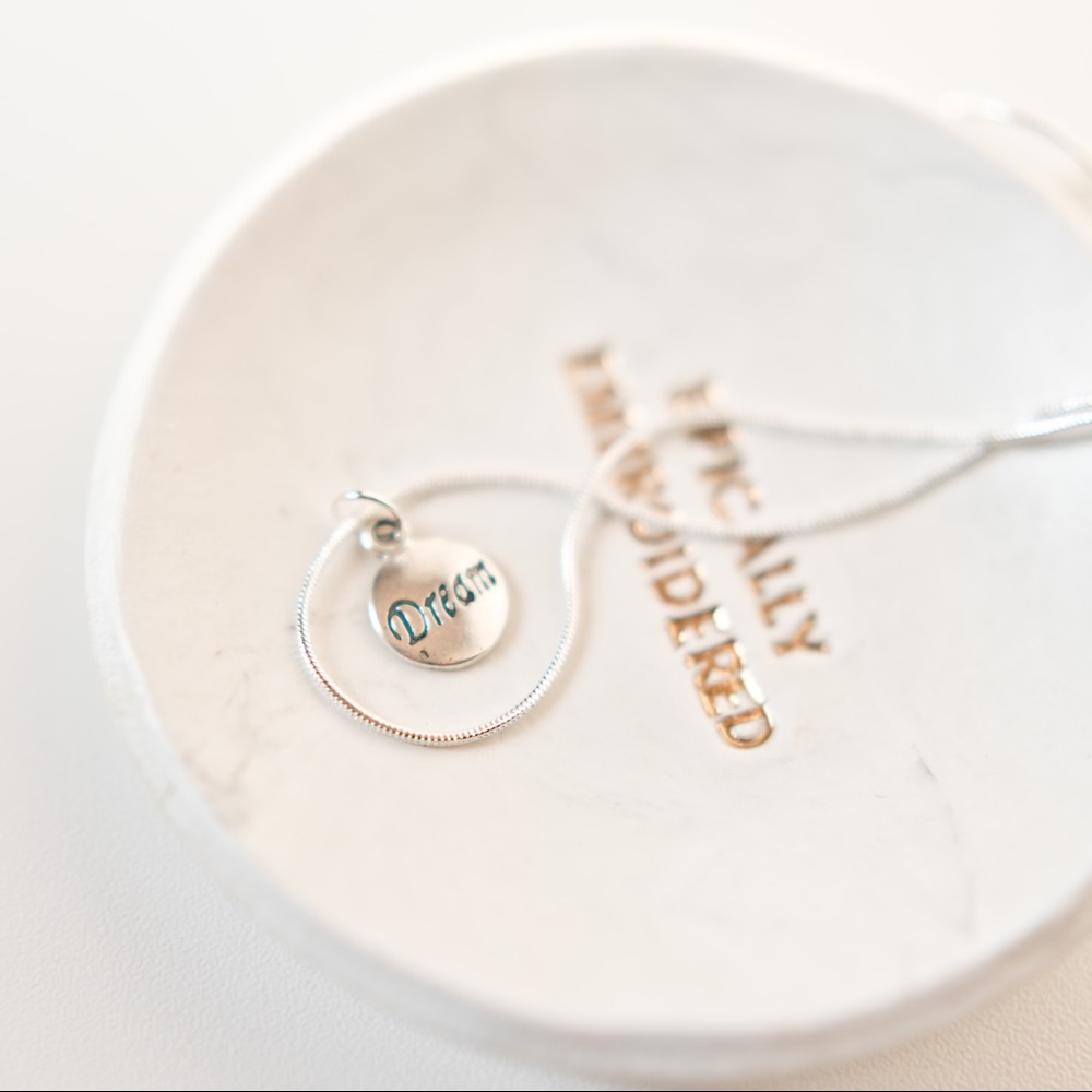 22 inch silver necklace with charm that says dream